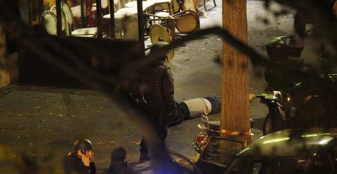 Agentes de la Policía francesa junto a una de las víctimas del ataque terrorista a la sala de conciertos Bataclán, en París, el pasado viernes. . EFE/EPA/YOAN VALAT