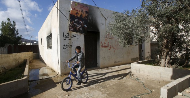 Niño palestino monta su bicicleta delante de la casa de la familia Dawabshe cerca de Nablús. REUTERS/Abed Omar Qusini