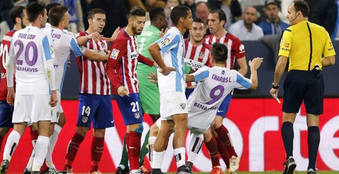 Jugadores del Málaga y el Atlético de Madrid, discuten en presencia del colegiado, Mateu Lahoz.EFE/Jorge Zapata.