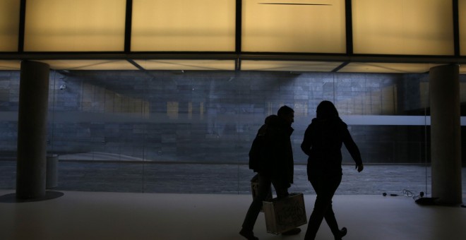 Dos personas pasan bajo el logo de Telefónica en la sede de la operadora en el distrito de Las Tablas de Madrid. REUTERS/Juan Medina