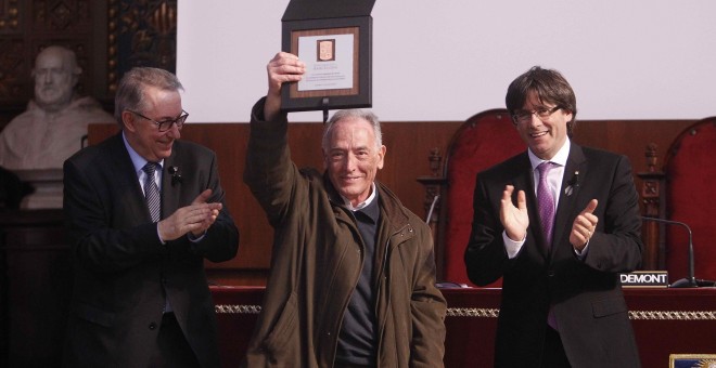 El padre Guardià (c), de la Comunidad de los Caputxins de Sarrià, recoge la placa conmemorativa en reconocimiento de la defensa de la libertad y de los valores democráticos de la mano del rector de la Universidad de Barcelona (i), Dídac Ramírez, ante el p