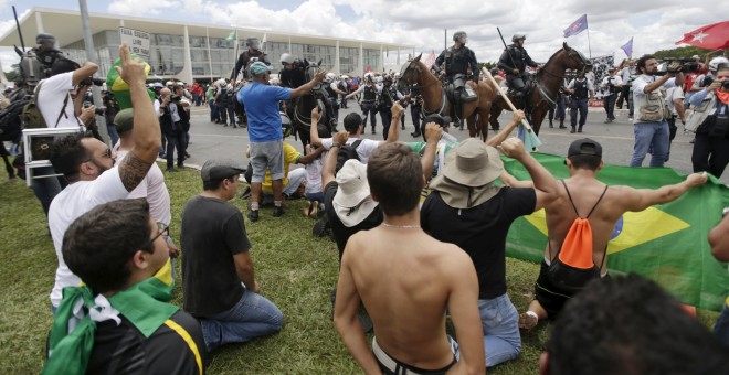 Un grupo de manifestantes protestan frente al Palacio de Planalto, la sede de la Presidencia de Brasil, contra el nombremiento comop ministro de Luiz Inacio Lula da Silva. REUTERS/Ricardo Moraes