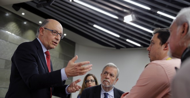 El ministro de Hacienda en funciones, Cristóbal Montoro , en presencia del secretario de Estado de Administraciones Públicas, Antonio Beteta, conversa con los periodistas al término de la rueda de prensa que ha ofrecido junto a la vicepresidenta del Gobie