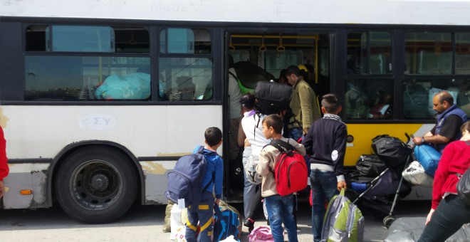 Uno de los autobuses que desaloja refugiados del puerto ateniense.