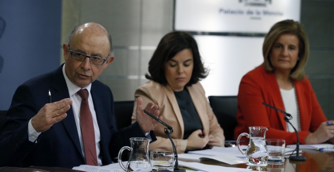 La vicepresidenta del Gobierno, Soraya Saenz de Santamaría (c), acompañada por los ministros de Hacienda y de Empleo, Cristóbal Montoro y Fátima Báñez, respectivamente, durante la rueda de prensa posterior a la reunión del Consejo de Ministros. EFE/Ángel