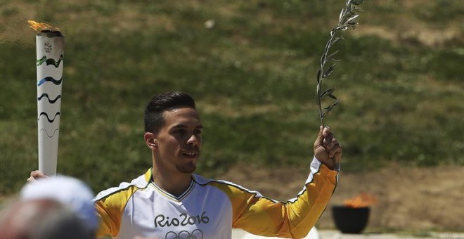 El campeón del mundo de gimnasia griego Lefteris Petrounias porta la antorcha olímpica. /EFE