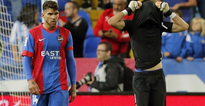 El portero del Levante Diego Mariño (d) y su compañero, el defensa argelino Carl Medjani, tras recibir el segundo gol del Málaga. /EFE