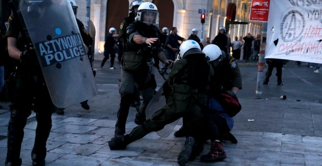 Policías griegos se abalanzan sobre un manifestante. /REUTERS