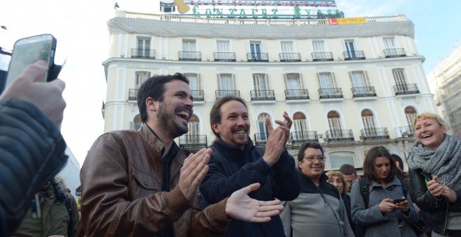 Alberto Garzón, líder de Izquierda Unida, y Pablo Iglesias, secretario general de Podemos, escenifican su acuerdo electoral en la Puerta del Sol de Madrid. PODEMOS