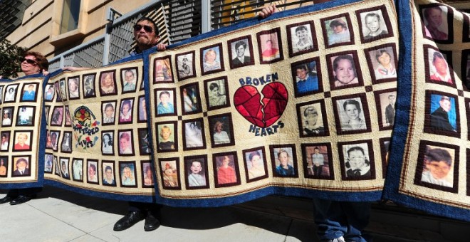 Fotos de niños que supuestamente han sufrido abusos sexuales durante una marcha frente a la catedral de Nuestra Señora de los Ángeles en Los Ángeles, California, el 1 de febrero de 2013. - AFP