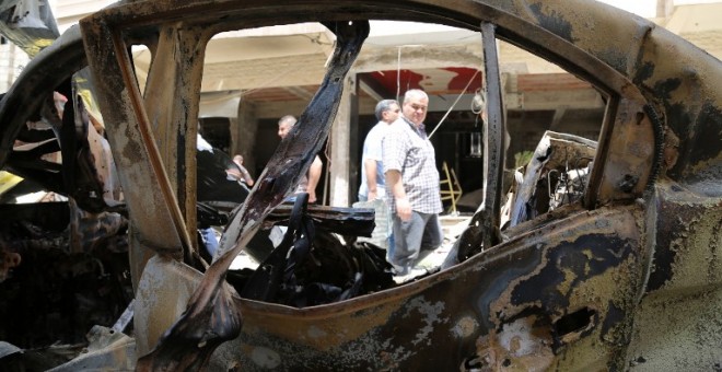 Un vehículo destruido tras un atentado del Estado Islámico junto a la ciudad siria de Qamishli. - AFP