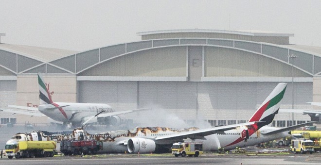 Los equipos de emergencia y los bomberos del Aeropuerto de Dubai rodean el aparato de Emirates Airline que se ha incendiado tras un aterrizaje de emergencia. REUTERS/Stringer