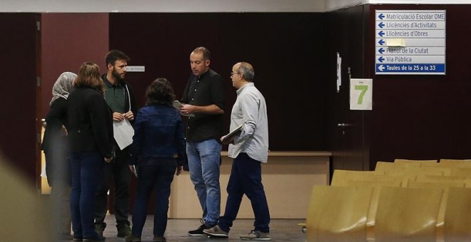 Los concejales del Ayuntamiento de Badalona atienden a los ciudadanos en el interior del recinto, tras desobedecer la resolución de un juzgado barcelonés contra su voluntad de abrir las dependencias municipales en el Día de la Hispanidad./ EFE