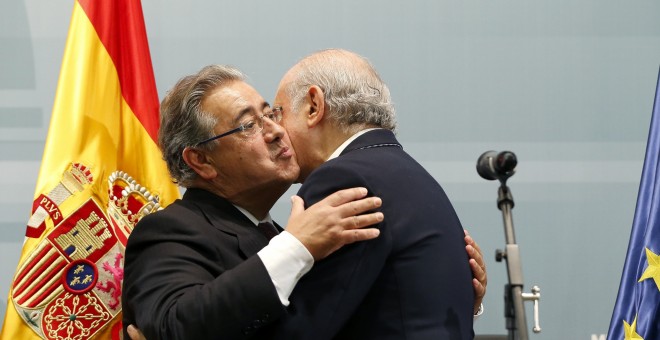 El nuevo ministro del Interior, Juan Ignacio Zoido, abraza a su antecesor en el cargo, Jorge Fernández Díaz, durante el acto de toma de posesión, en la sede del Ministerio en Madrid. EFE/Mariscal