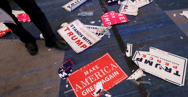 Un asistente a la fiesta del candidato republicano pasa sobre las pancartas y banderines en el suelo tras la celebración de la victoria de Donald Trump en las elecciones presidenciales en EEUU. REUTERS / Andrew Kelly