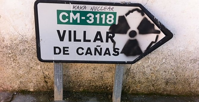 Una pintada contra el cementerio nuclear en un indicador de carrera de Villar de Cañas. EFE