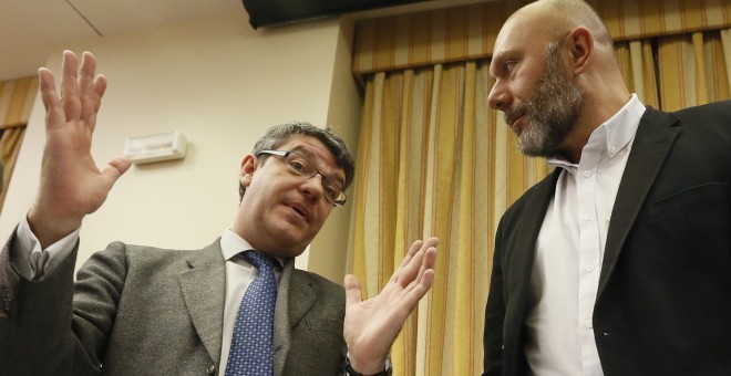 El ministro de Energía, Álvaro Nadal, conversa con el presidente de la Comisión de Energía y diputado de Unidos Podemos, antes de comparecer para explicar el comportamiento de los precios en los mercados de la energía. EFE/Fernando Alvarado