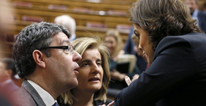 La vicepresidenta del Gobierno, Soraya Sáenz de Santamaría, conversa con los ministros, de Energía, Álvaro Nadalm y de Empleo, Fátima Báñez, durante el pleno en el Congreso de los Diputados. EFE/Fernando Alvarado