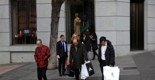 Varios turistas orientales con sus compras en la zona comercial de la madrileña calle de Serrano. REUTERS/Susana Vera