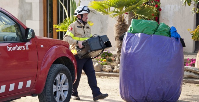 Un bombero con restos del castillo hinchable del restaurante Mas Oller, de Caldes de Malavella (Gerona), que ha volado unos 40 metros por encima del tejado del establecimiento, provocando la muerta de una una niña, y heridas a otros seis menores. EFE/Robi