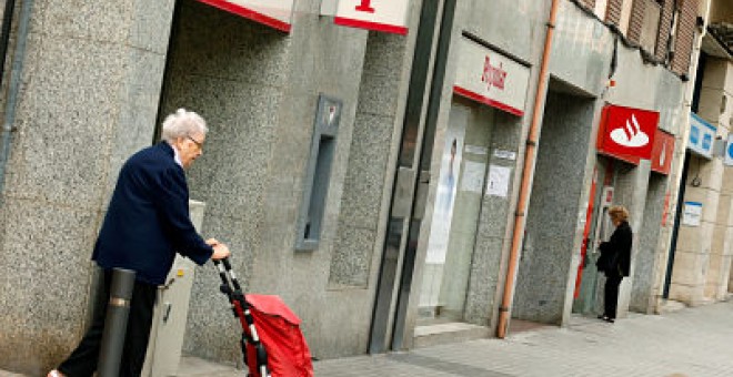 Una mujer pasa junto a una sucursal del Banco Popular en Barcelona. REUTERS/ Albert Gea