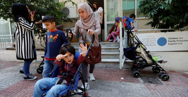 Khalissa y su familia salen de un centro de protección familiar para refugiados en Atenas. 'Mi marido ha estado en Alemania dos años. Hace unos días tuve una respuesta positiva a mi petición de reunificación familiar para mi familia, pero not engo ni ide