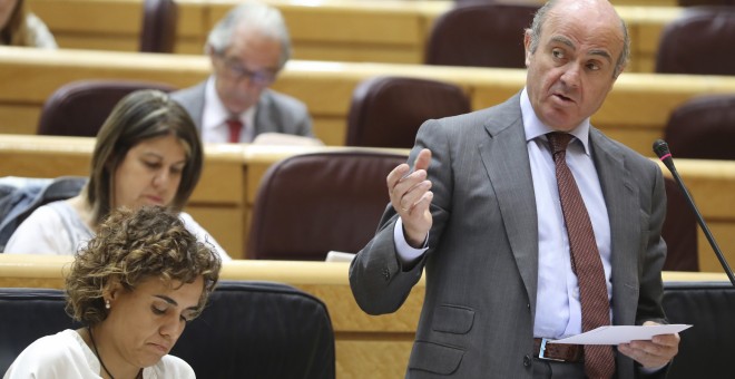 El ministro de Economía, Luis de Guindos, y la titular de Sanidad, Dolors Montserrat, durante la sesión de control al Gobierno en el pleno del Senado. EFE/Ballesteros