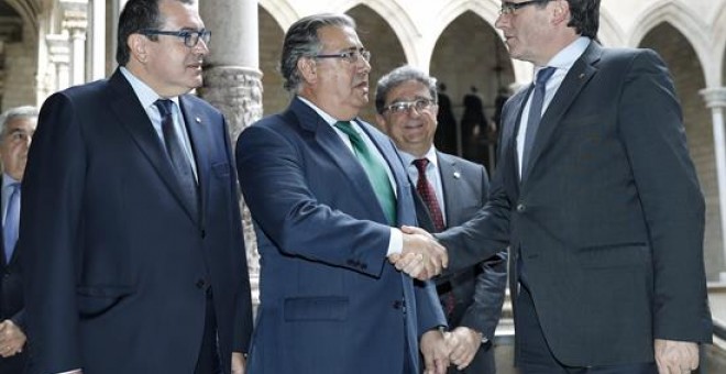 Carles Puigdemont saluda Juan Ignacio Zoido abans de l'inici de la reunió de la Junta de Seguretat de Catalunya. EFE/Andreu Dalmau