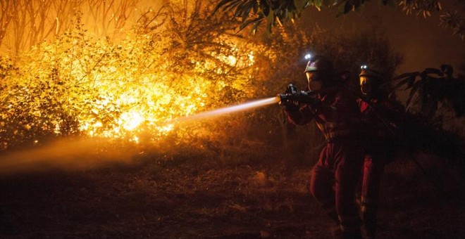 Efectivos de la Unidad Militar de Emergencias (UME) trabajan en la extinción del incendio forestal declarado ayer por la tarde en el municipio de Verín que obligó a activar la alerta por 'situación 2' por proximidad a núcleos poblados y a cortar carretera