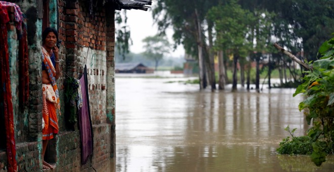 Una mujer observa los efectos de la inundación desde la puerta de su casa, en la zona de Janakpur, en Nepal. REUTERS/Navesh Chitrakar