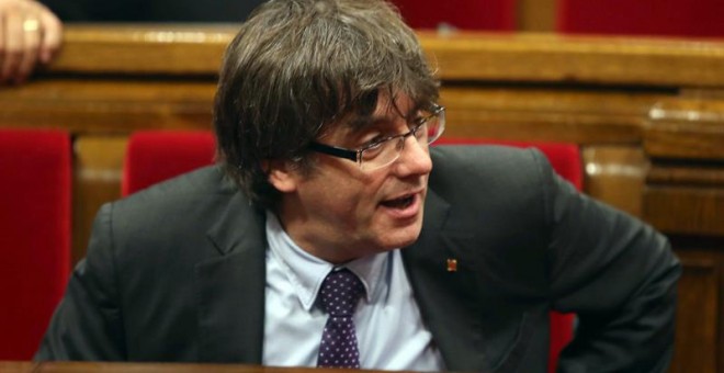 El presidente de la Generalitat, Carles Puigdemont, abandona el hemiciclo tras volver a suspenderse el pleno por una nueva petición para reunir de nuevo a la Mesa y Junta de Portavoces, tras solicitud de Junts pel Sí y de la Cup de la alteración del orden