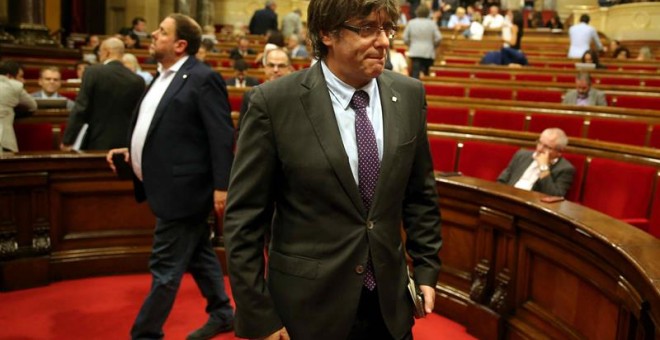 El presidente de la Generalitat de Cataluña, Carles Puigdemont (c) y el vicpresidente del Govern, Oriol Junqueras (i) y la presidenta del grupo parlamentario de Ciudadanos, Inés Arrimadas (2d), momentos antes de abandonar hoy el hemiciclo del Parlament de