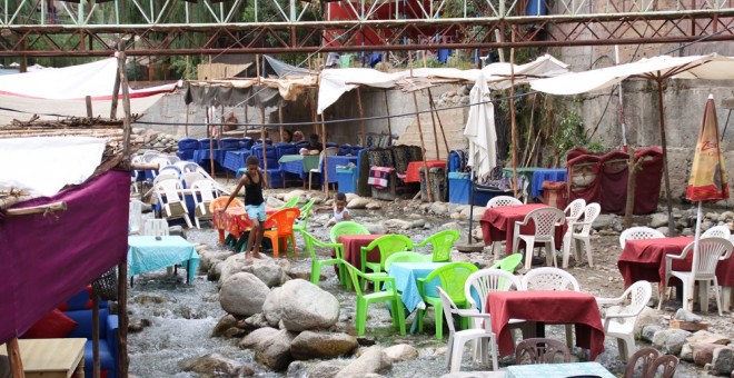 Unos niños juegan en el río Ourika (Alto Atlas), donde los restaurantes sacan las mesas al río como reclamo para comer con los pies frescos en el río.