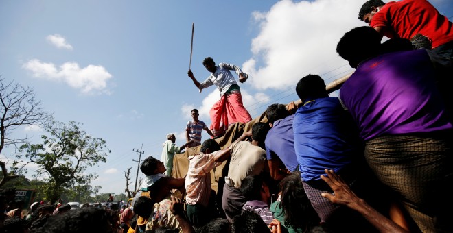 Un hombre usa una vara para controlar a la multitud mientras proporciona suministros de socorro a los refugiados Rohingya en el campamento de Cox, en Bangladesh. REUTERS / Mohammad Ponir Hossain