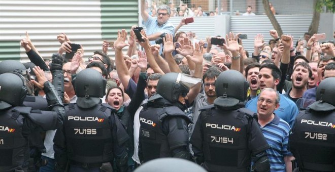 Agentes de la policía nacional forman un cordón policial en el exterior del IES Tarragona. Las cargas policiales ante los colegios electorales y el insólito modo de votación están marcando la jornada del 1-O en Catalunya. EFE/Jaume Sellart