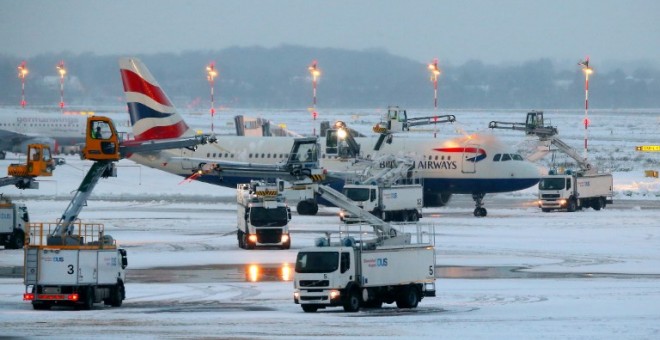 Un avión rodeado de nieve ne el aeropuerto de Duesseldorf. - AFP