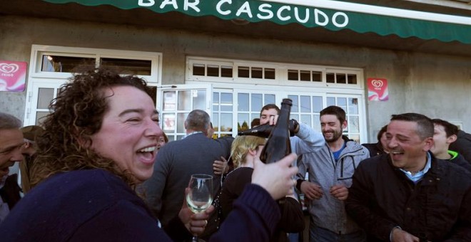 Clientes del Bar Cascudo, ubicado en la parroquia vilalbesa de San Juan, que ha vendido 50 series del número 71.198, agraciado con el premio Gordo del Sorteo Extraordinario de la Lotería de Navidad, lo celebran. | ELISEO TRIGO (EFE)