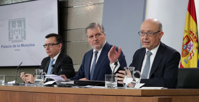 El ministro de Economía Román Escolano (i), El ministro Portavoz Iñigo Méndezde Vigo (c), y el ministro de Hacienda Cristóbal Montoro, durante la rueda de prensa posterior al Consejo de Ministros, celebrado en el Palacio de La Moncloa. EFE/Zipi