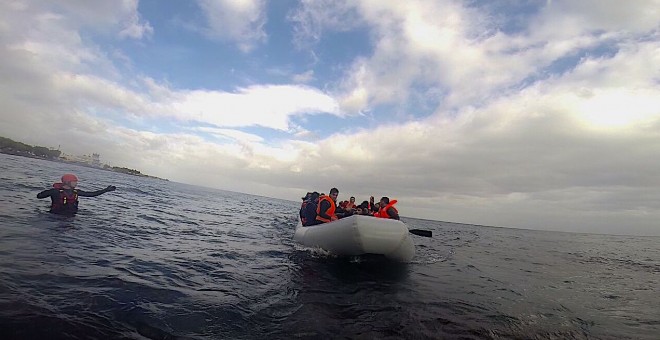 El bombero Enrique Rodríguez, uno de los acusados, en el agua, junto a un dinghy en Lesbos, en enero 2016./ Archivo de Julio Latorre