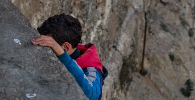 Un menor extranjero no acompañado, en las escolleras del puerto de Melilla.- JOSÉ PALAZÓN /FUNDACIÓN RAÍCES