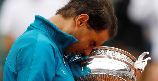 Nadal se abraza a la Copa de los Mosqueteros. (CHARLES PLATIAU | REUTERS)