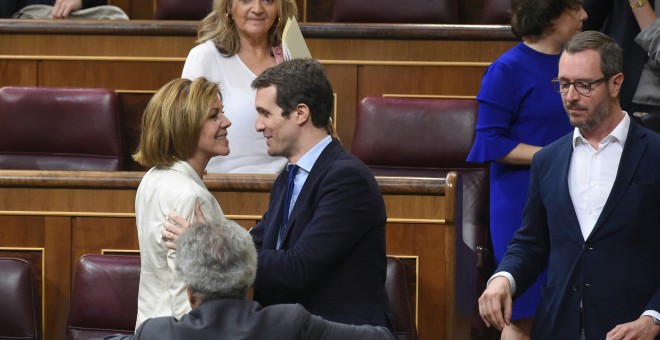 La secretaria general del PP, María Dolores de Cospedal, saluda al vicesecretario de comunicación del partido, Pablo Casado, durante el pleno del Congreso celebrado en Madrid. EFE/Fernando Villar