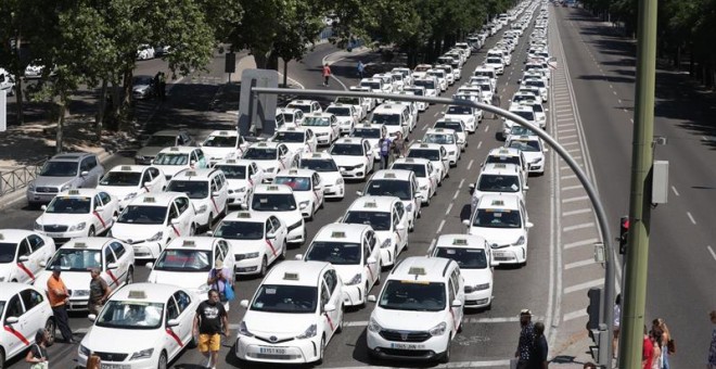 Taxis permanecen concentrados a su paso por el ministerio de Fomento en Madrid. EFE | Zipi