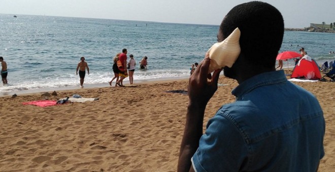 El Peter, vingut des de Nigèria, escolta un dels cargols de mar on persones migrades expliquen com han creuat el Mediterrani. CEAR