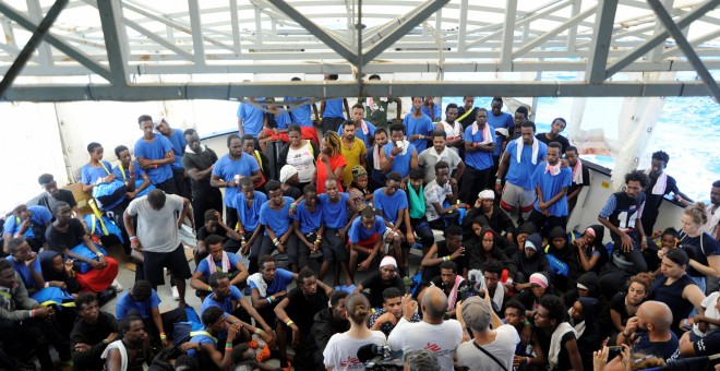 Migrantes a bordo del barco MV Aquarius escuchan las instrucciones de los activistas, antes de su llegada a Malta. REUTERS/Guglielmo Mangiapane