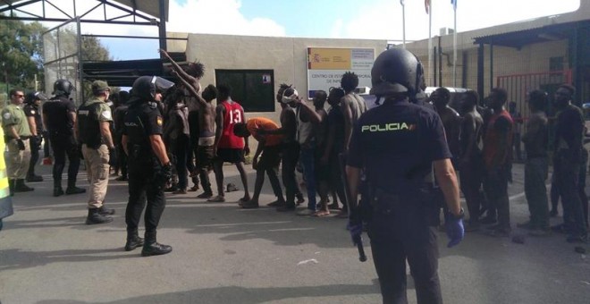 Migrantes custodiados por efectivos de la Policía Nacional esperan su entrada al Centro de Estancia Temporal de Inmigrantes (CETI) de Ceuta, tras conseguir saltar la valla fronteriza. EFE/José M. Rincón