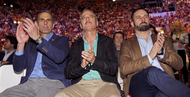 El presidente de Vox, Santiago Abascal (d), el secretario general, Javier Ortega Smith (i), y uno de los fundadores de la formación, José Antonio Ortega Lara (c), durante el acto que Vox ha celebrado en el Palacio de Vistalegre de Madrid. /EFE