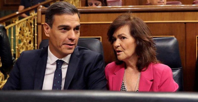 El presidente del gobierno Pedro Sánchez, conversa con la vicepresidenta del gobierno Carmen Calvo en el Congreso de los Diputados. (BALLESTEROS | EFE)