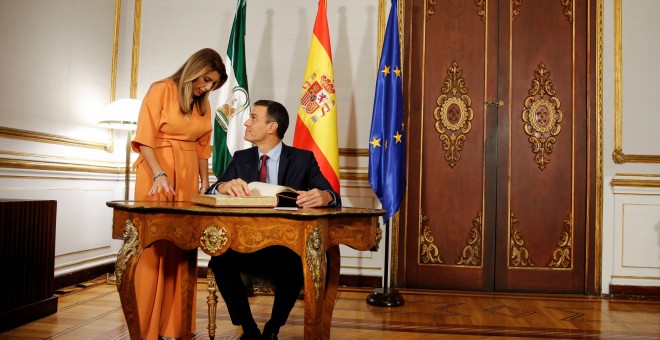 El presidente del Gobierno, Pedro Sánchez, firma en el libro de visitas del Palacio de San Telmo, sede de la Presidencia de la Junta de Andalucía en Sevilla, en presencia de Susana Díaz. REUTERS/Marcelo del Pozo