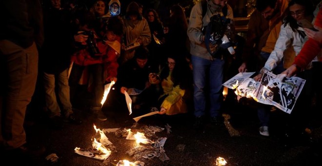 Participantes en una movilización convocada por los Comités de Defensa de la República (CDR) en el primer aniversario de la declaración unilateral de independencia aprobada por el Parlament ,queman fotografías del Rey frente a la delegación del Gobierno e